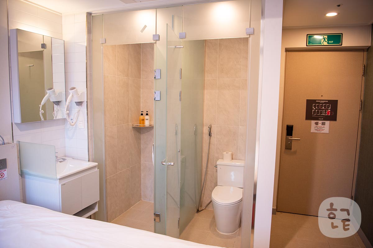 ソウルNホテルのダブルルームの内観写真 トイレとシャワールームと机